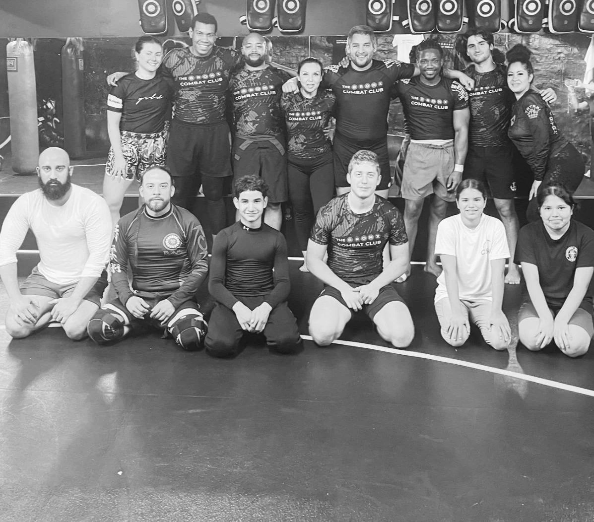 Bronx Combat Club coaches and students posing together on the gym mats